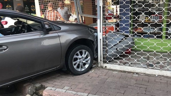 Çarpışan otomobillerden biri marketin kepenklerine girdi!