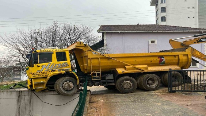 Hafriyat kamyonu istinat duvarında askıda kaldı